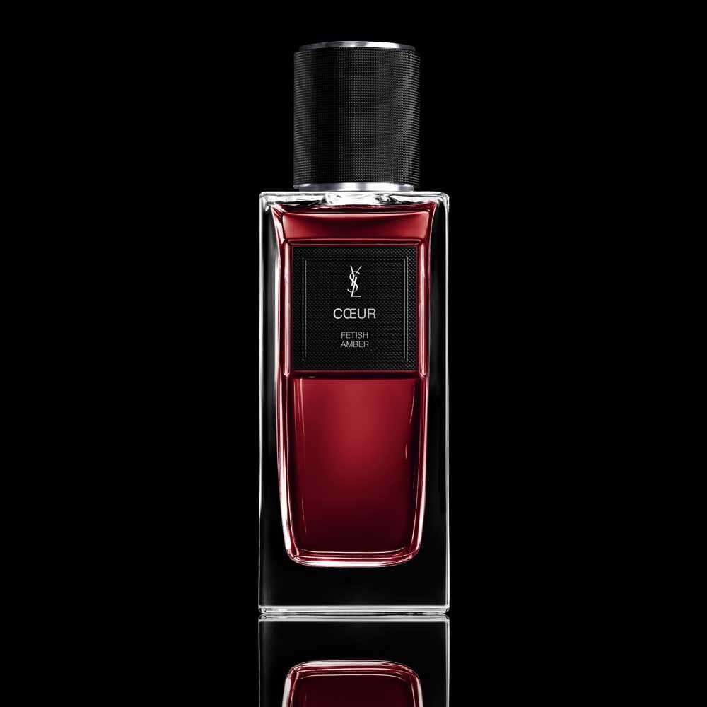 COEUR Eau de Parfum ruby-red bottle with black cap on a reflective YSL background.