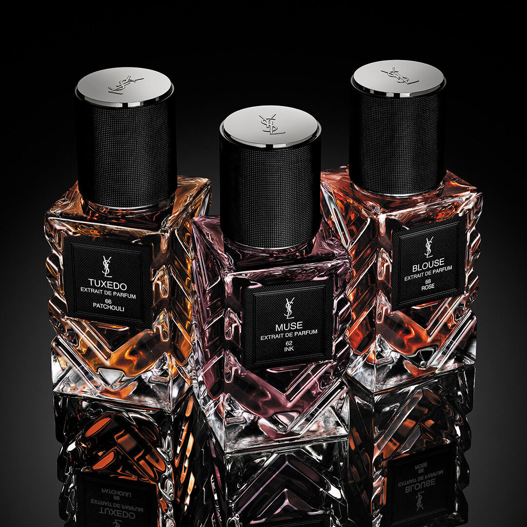 Close-up of YSL Muse extrait de parfum bottle showing faceted red glass and logo.