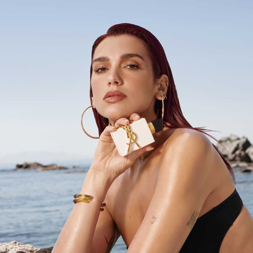 YSL Libre L’Eau Nue campaign – model holding the fragrance bottle against a Mediterranean backdrop