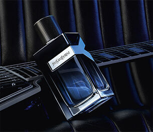 YSL Y Eau de Parfum bottle on an electric guitar, representing a bold, intense fougere fragrance for men.