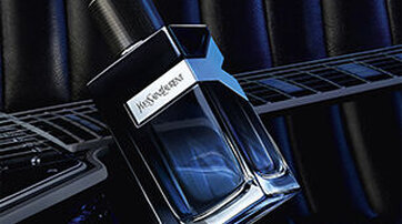 YSL Y Eau de Parfum bottle on an electric guitar, representing a bold, intense fougere fragrance for men.