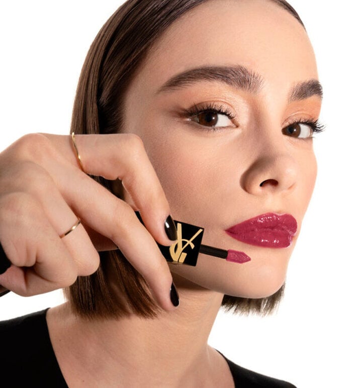 Model applying YSL The Inks Vinyl Cream lip stain shade 622 Plum Liberation