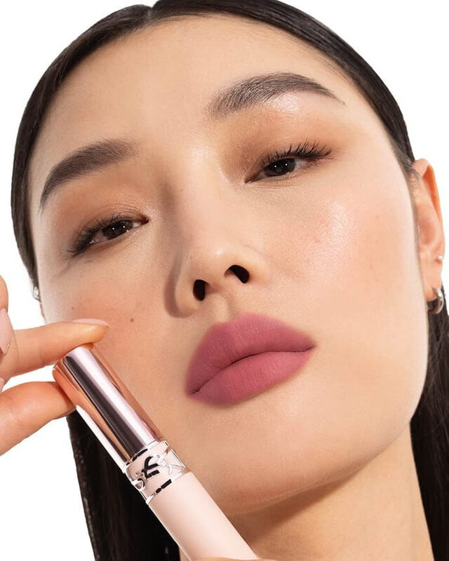 Mei J wearing YSL LOVENUDE Lip Blusher, shade 1, on fair skin, holding the product.