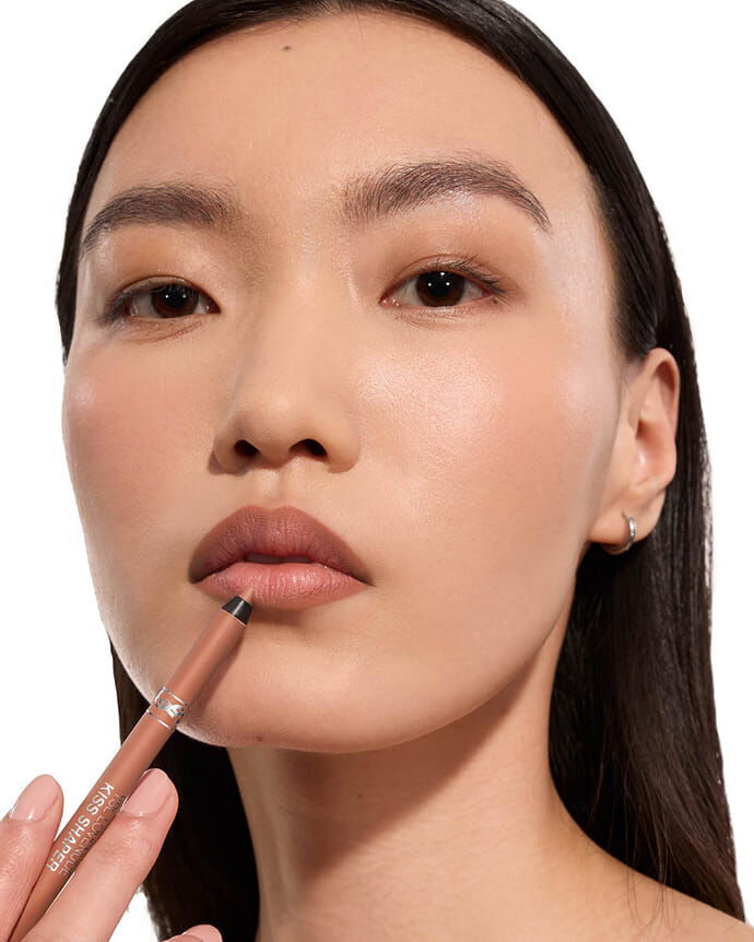 Jia Lu Yi wearing YSL LOVENUDE Kiss Shaper, shade 102, on light skin, holding the product.