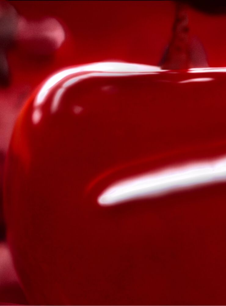 Juicy red cherries symbolizing the cherry accord in Black Opium Over Red fragrance