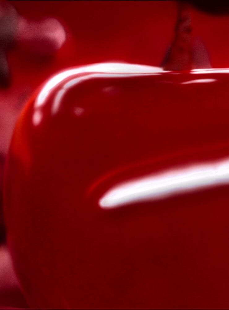 Juicy red cherries symbolizing the cherry accord in Black Opium Over Red fragrance