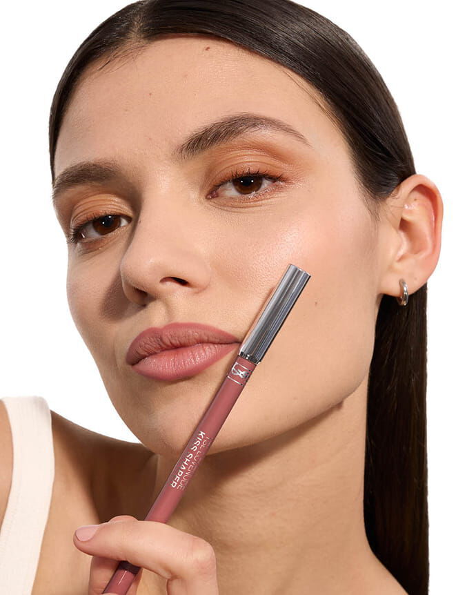 Adrienne wearing YSL LOVENUDE Kiss Shaper, shade 101, on fair skin, holding the product.