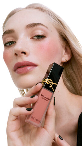 Model with medium skin tone showcasing YSL Make Me Blush Liquid Blush in a rosy pink shade