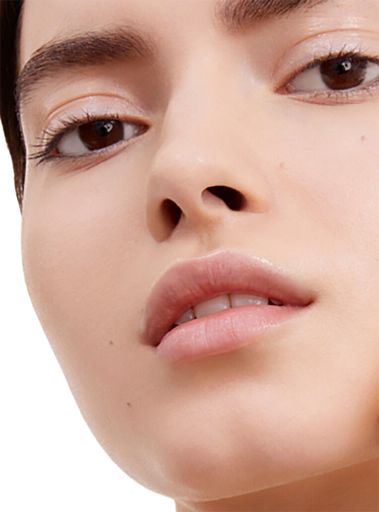 Close-up of a model with radiant skin showcasing YSL Le Cushion Encre de Peau with 94% natural-origin formula