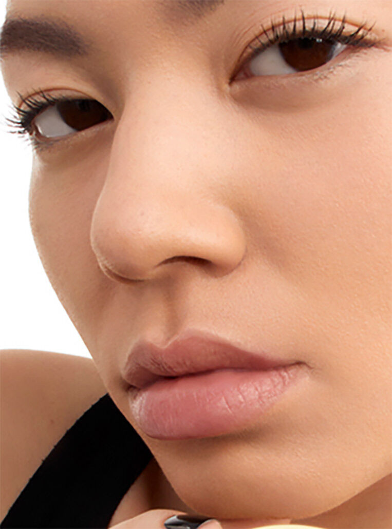 Close-up of a model's flawless complexion highlighting the 24-hour luminous matte finish of YSL Le Cushion Encre de Peau
