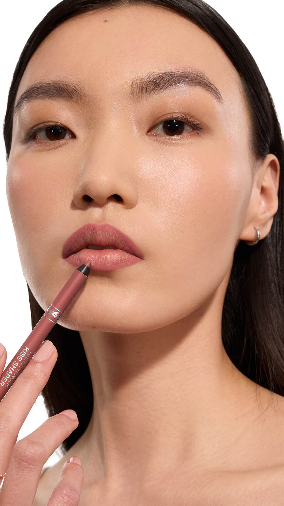 Adrienne holding YSL LOVENUDE Kiss Shaper 26 in Shade 107, full- face portrait on white background.