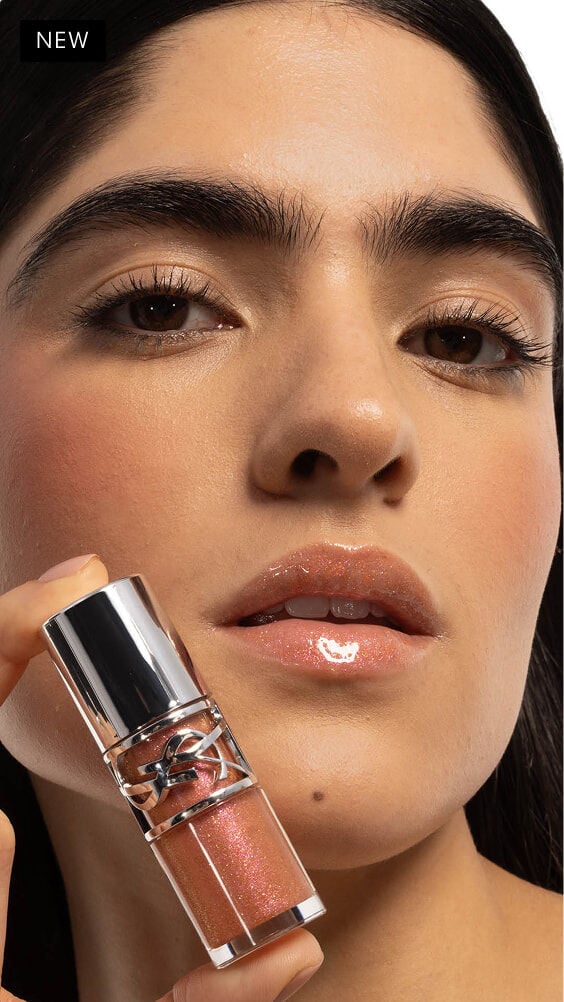 Natalia's gaze captivates, lips adorned with YSL LOVESHINE Plumping Lip Oil Gloss 12 Stardust, product held close.