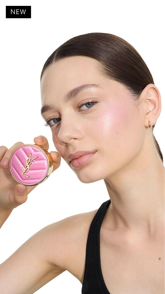 Oksana, fair skin, holding a pink YSL Make Me Blush Powder Blush in shade 10, showcasing a subtle blush on her cheek.