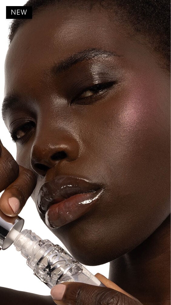 Nyaluak, deep-skinned, with YSL LOVESHINE Plumping Lip Oil Gloss in Shade 11 Radiant Glass, showcasing glossy lips.