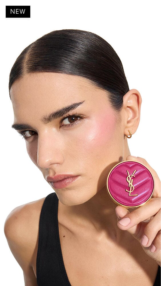 Iman, medium skin, holding a fuchsia YSL Make Me Blush Powder Blush in shade 66, showcasing vibrant blush on her cheek.