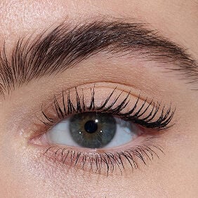 Close-up of an eye with light skin tone, showcasing lengthened lashes from YSL Lash Latex Mascara with level three intensity.