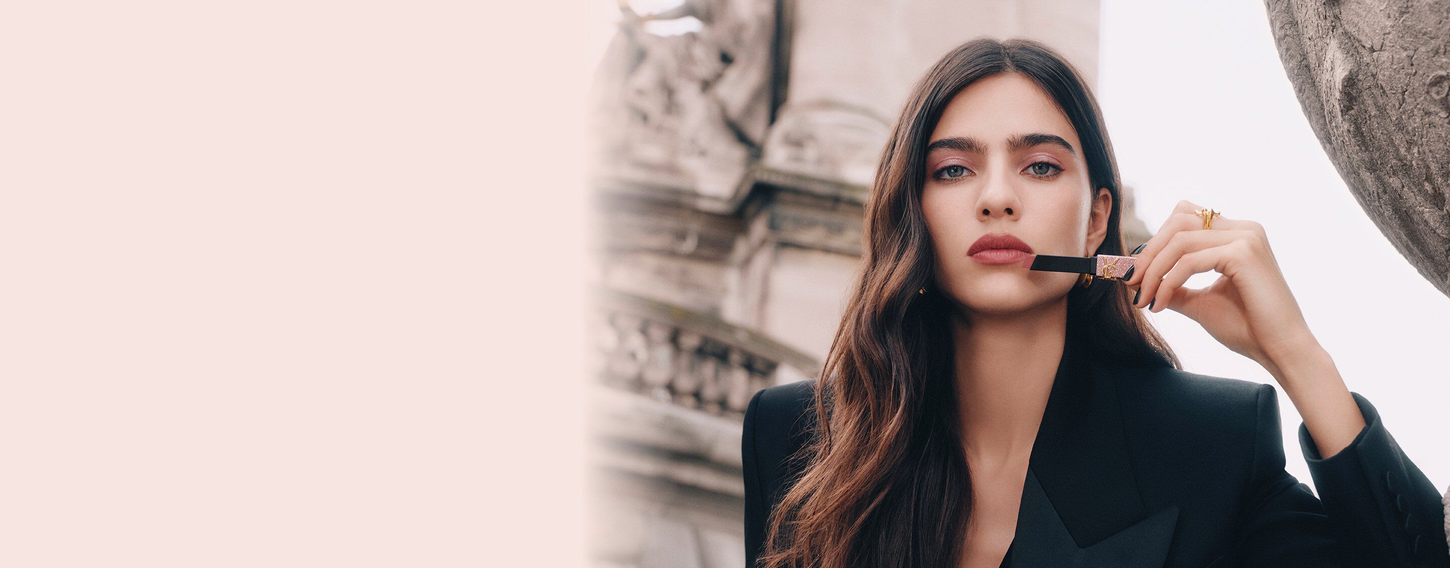 Model Loli Bahia holding YSL Rouge Pur Couture The Slim Lipstick in shade 835, applied on her lips, with a glitter case.