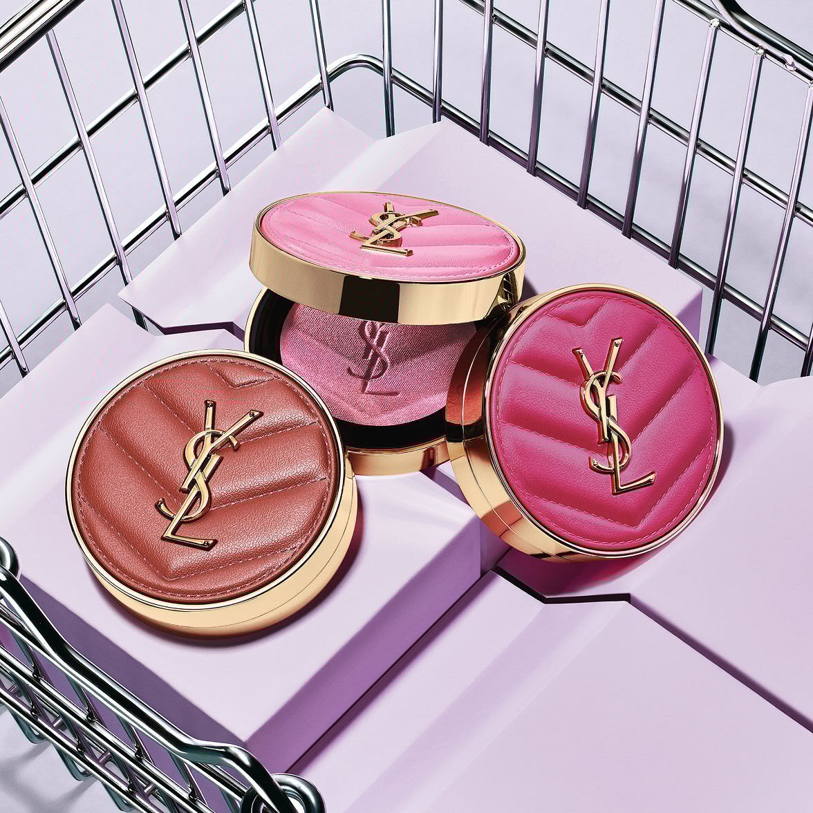 Three YSL Make Me Blush Powder Blush in shades 10, 12, and 66, displayed on purple blocks in a metallic basket.
