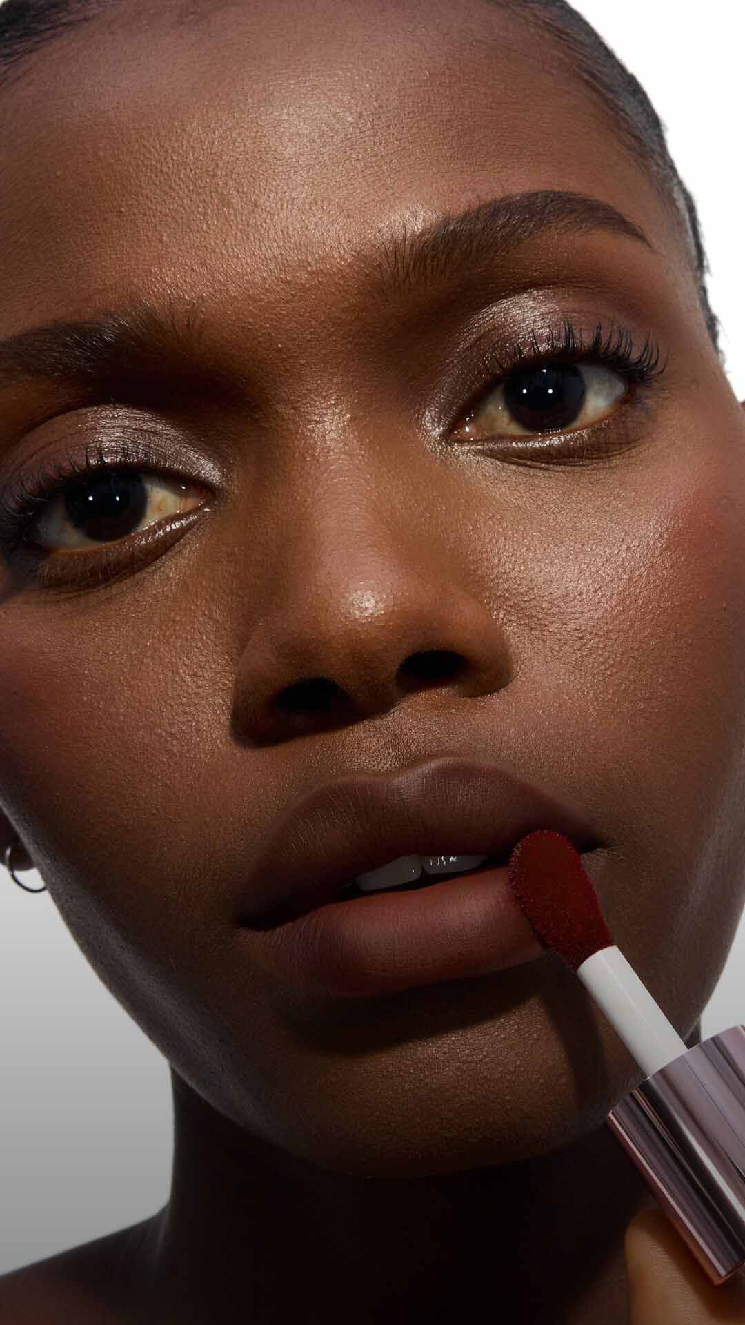 Close-up of a model's cheek wearing the Make Me Blush routine: Powder #15 Chili Crush layered with Cream #65 Strawberry Seduction for a bold, post-workout glow.