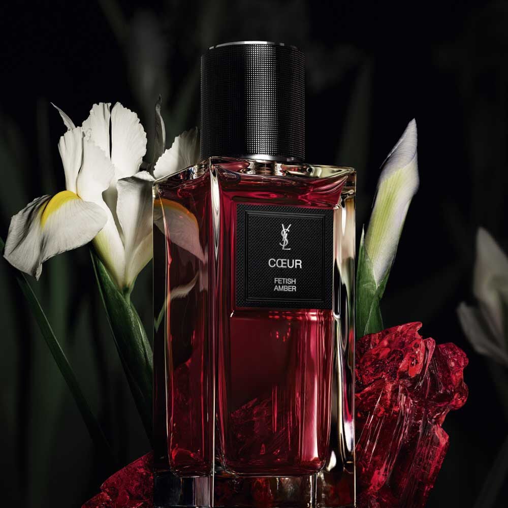 CŒUR Eau de Parfum by YSL bottle
surrounded by noble Iris pallida and
red amber on a dark background.