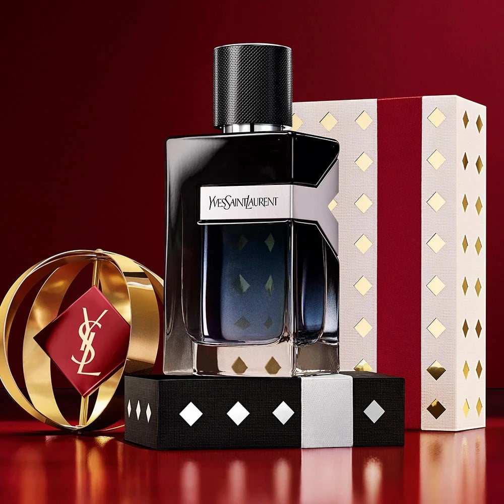 Multiple YSL LIBRE fragrance bottles layered over luxury gold-patterned Holiday gift packaging.
